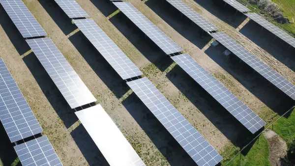 En stor solcellspark tar form. Solpaneler i rader fångar solens energi för att starta en grön framtid.